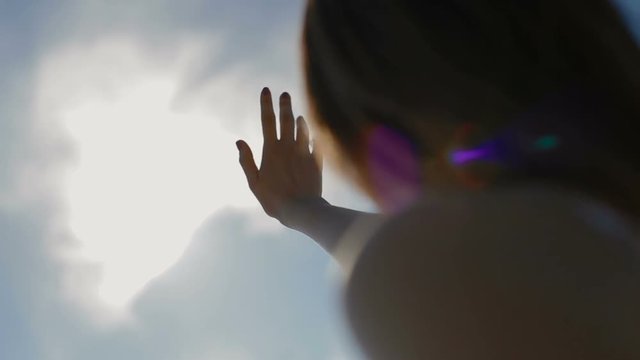 The young girl pulls a hand to the sun