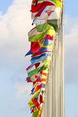 different countries flags on flagpoles on the sky background