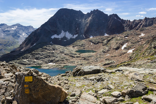 Hiking in Aosta valley, Grauson walloon, Cogne, Italy. View of third lake of Lussert from Laures col (3000 m.). Vertical orientation.