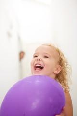 Fototapeta na wymiar Cute little girl holding balloon and laughing