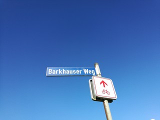 Hinweisschild an der Abzweigung zum Gut Barkhausen vor blauem Himmel im Sonnenschein am Radweg in...