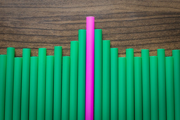 difference pink and green drinking straw on wood board