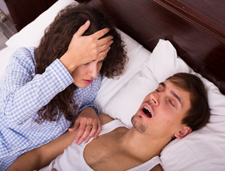  man and brunette girl sleeping tight in bed
