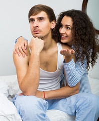  man and brunette girl sleeping tight in bed