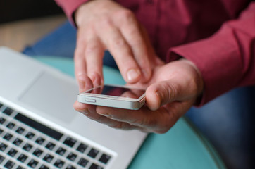 Aged man using his phone and lap top