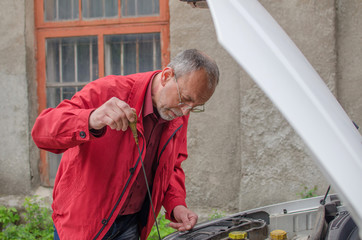 Aged man fixing the car