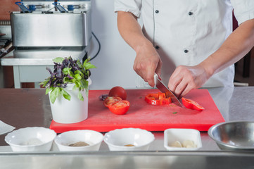 cook prepares in the kitchen Close-up of a hand cutting vegetabl