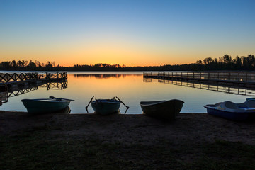 Лодки в предрассветный час на фоне озера