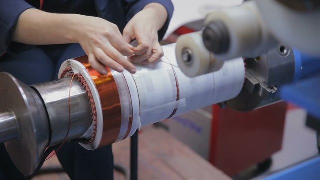 Transformer, engine production. Worker operates with electric cooper wires, winding of the transformer. HD.