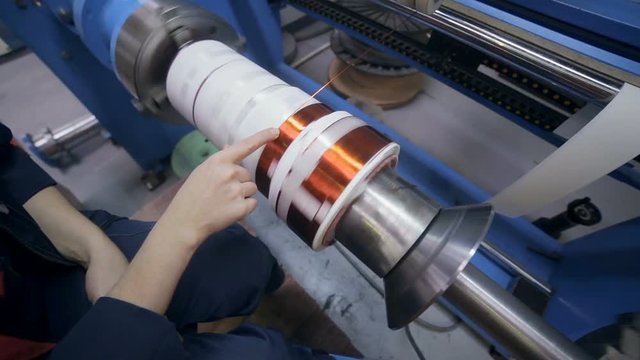 Transformer, engine production. Worker operates with electric cooper wires, winding of the transformer. HD.