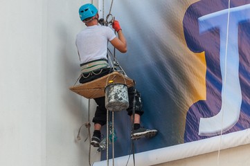 Climber on a vertical wall mounted billboard