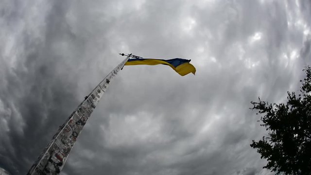 Flag of Ukraine develops on the background of sky.