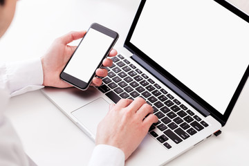 Businessman using laptop and mobile phone