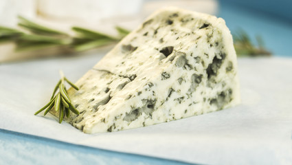 Blue cheese with rosemary on wooden board