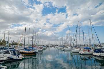 Naklejka na ściany i meble Yachts standing in two rows with the reflection in the sea in a