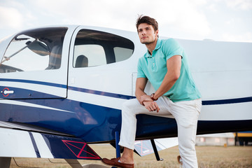 Young man pilot standing near small aircraft © Drobot Dean
