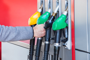 Color coded fuel nozzles at petrol station  horizontal image