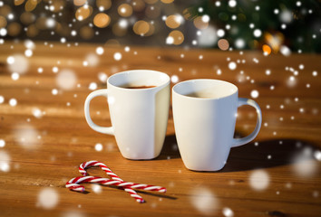 christmas candy canes and cups on wooden table