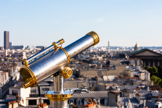 Touristic telescope overlooking Paris from the roof of department store