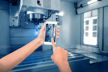 Man use mobile smartphone, blur image of CNC machining shop as background...