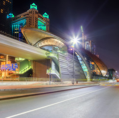 Panoramic view of metro station and road in Financial district at night, Dubai, UAE