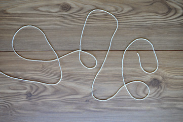 String intertwined on a wood background