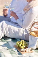 happy senior couple having picnic on summer beach