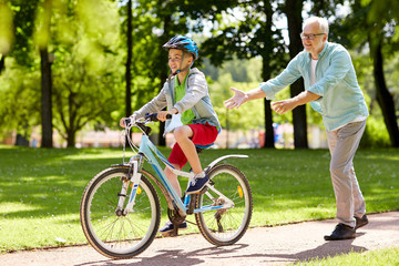 Fototapeta premium grandfather and boy with bicycle at summer park