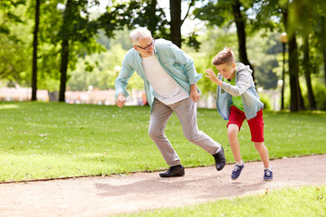 grandfather and grandson racing at summer park