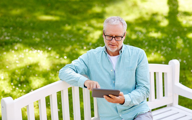 senior man with tablet pc at summer park