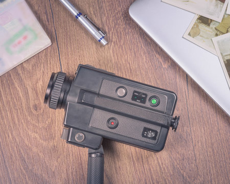 Vintage image with old Camera,old photo,laptop,pen and passport on wood table.
