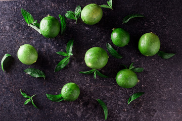 Lime background. Fresh limes with slices and mint leaves around.