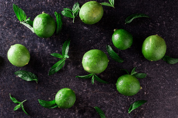 Lime background. Fresh limes with slices and mint leaves around.