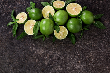 Lime background. Fresh limes with slices and mint leaves around.
