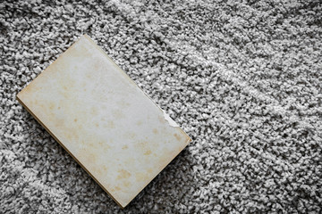 old book on rustic carpet texture
