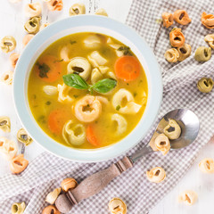 Delicious Vegetable Soup with Tortellini on white wooden table