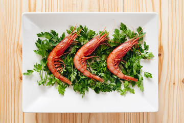 Raw prawns and parsley on white dish