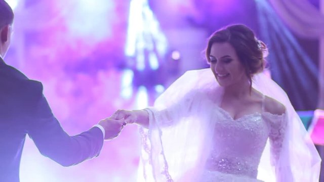 Beautiful brunette bride and handsome groom dancing first dance at the wedding party