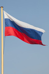 Fototapeta na wymiar Russian flag on the mast, over blue sky