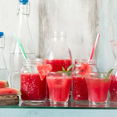 Watermelon drink in glasses with slices of watermelon mint and lemon,