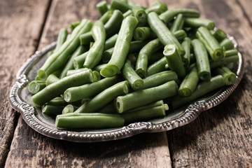 Bunch of freshly picked green beans on a wooden surface.