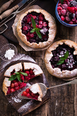 Blueberry,cherry,raspberry and blackcurrant galette on w wooden background.