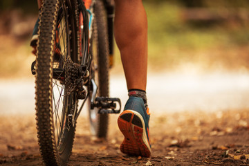 Rear view of mountain bike and man's legs.