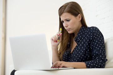 woman using laptop computer networking or online internet shopping at home couch