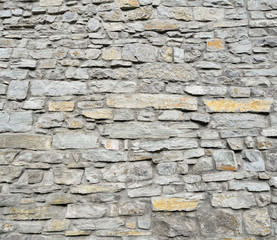 Gray pattern of old style design decorative cracked real stone wall surface with cement. Part of a stone wall, for background or texture. Antique natural stonewall background