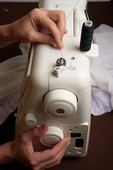 Woman threading on sewing machine