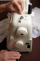Woman threading on sewing machine