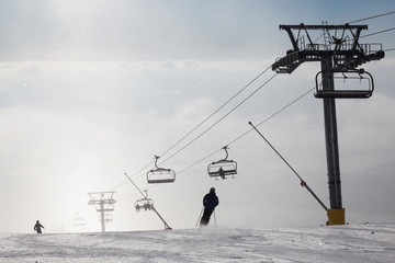 Skiers on ski slopes  in  fog.