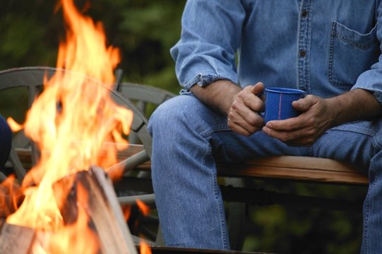 Man Sitting By A Fire