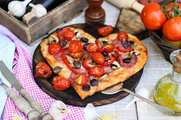 Pizza with pepperoni, tomatoes, mozzarella, on vintage wooden table background. Valentines Day concept